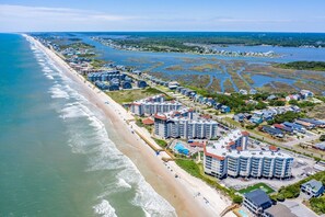 Ein Küstenort mit Strandhotels, einem Sandstrand und einer Marina.