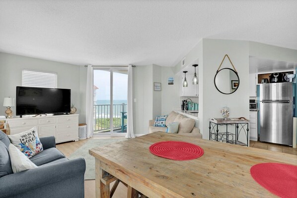 Ein modernes Apartment mit Wohnzimmer, Küche und Balkon.