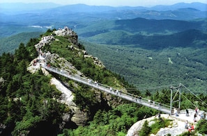 Un puente colgante sobre una zona montañosa, con vistas del paisaje circundante.