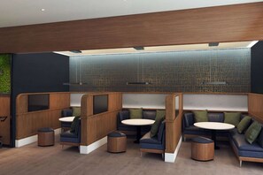 A modern lounge area with wooden partitions, round tables, and cushioned seating. - Near Grandfather Mountain + Bistro & Indoor Pool (Sugar Mountain)