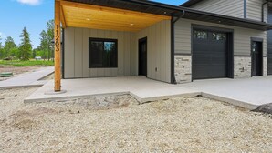 A modern house with a covered porch, a garage, and a stone facade.