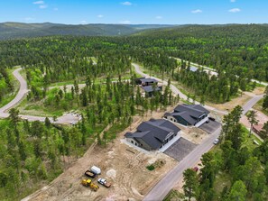 A residential area with multiple houses, roads, and a forested landscape. - Upscale Property w/ Giant Garage and Mezzanine Entertaining Space! (Lead)