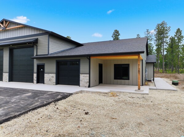 A modern two-story house with a garage, a covered porch, and a small shed. - Upscale Property w/ Giant Garage and Mezzanine Entertaining Space! (Lead)
