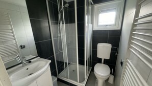 A bathroom with a shower enclosure, toilet, and sink. - Holiday Home in Susteren With Sauna (Susteren)