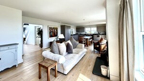 Ein geräumiges Wohnzimmer mit Sofa, Couchtisch und Essbereich.