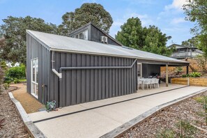 A modern house with a covered patio, a water feature, and a garden. - Modern Beach holiday House in Rhyll close to Beach, Restaurants, boating (Rhyll)