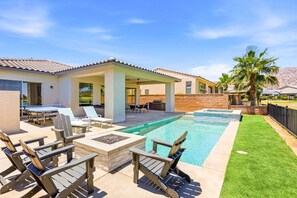 A backyard with a swimming pool, outdoor seating, and a covered patio area. - Golf Getaway | Pool, Spa, Arcades, BBQ, PGA West! (La Quinta)