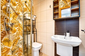 Ein Badezimmer mit Dusche, Toilette und Waschbecken.