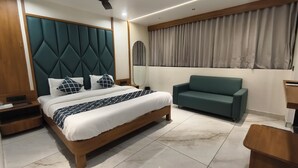 Una camera da letto moderna con un letto, una poltrona verde, un comodino e uno specchio.