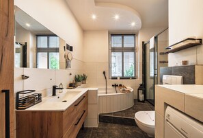 A modern bathroom with a bathtub, a toilet, and a sink. - RentPlanet - Apartament Bukowska (Poznań)