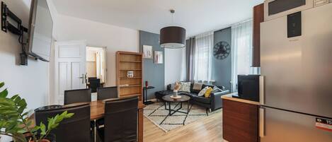 A modern apartment with a dining area, living room, and kitchen.