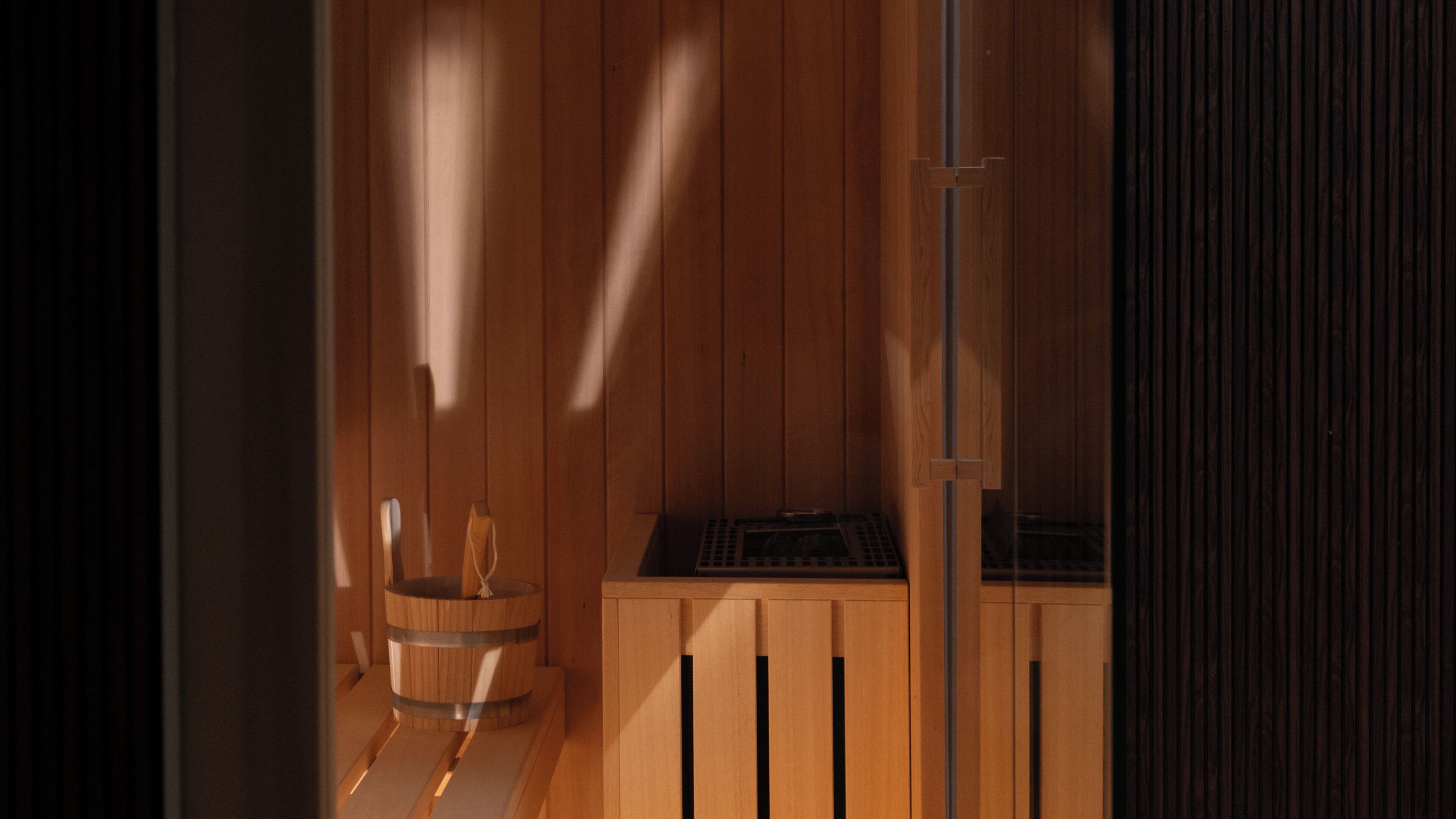 Un sauna de madera con un banco de madera y un barril.