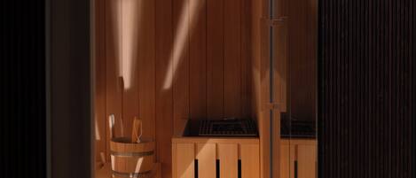 Un sauna de madera con un banco de madera y un barril.