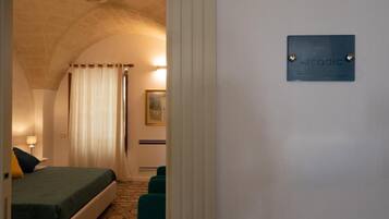 Een hotelkamer met een bed, een nachtkastje, een lamp, een schilderij en een bord aan de muur.