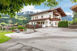 Un bâtiment à deux étages doté d’un balcon, d’une allée et offrant une vue sur un paysage montagneux.