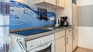 Une cuisine avec un revêtement mural bleu, des appareils en acier inoxydable et un plan de travail en granit.