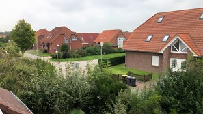 Ein Wohngebiet mit mehreren Häusern, jedes mit einem geneigten roten Dach und einem kleinen Fenster.