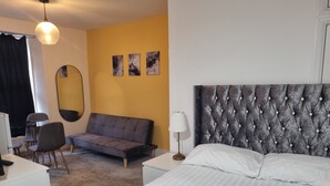 Une chambre d’hôtel avec un lit, un canapé, un bureau et une chaise.