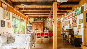 A cozy interior with a wooden ceiling, a dining area with a red tablecloth, and a kitchen with wooden cabinets and a sign reading 'BIERE D'ALSACE'. - Gite Geranium – La Cour de J'Anne in the Heart of Old Schiltigheim (Schiltigheim)