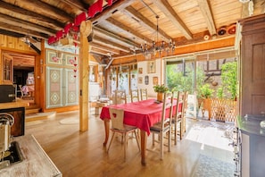 Ein Holzinterieur mit Esstisch, Stühlen und einer Kronleuchter.