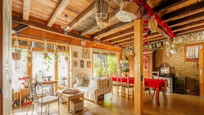 A cozy room with a wooden ceiling, a dining area with a red tablecloth, and a kitchen area. - Gite Geranium – La Cour de J'Anne in the Heart of Old Schiltigheim (Schiltigheim)