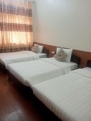 A hotel room with three single beds, wooden headboards, and a large window with curtains. - Tinh Doi Sapa Guest House (Sa Pa)
