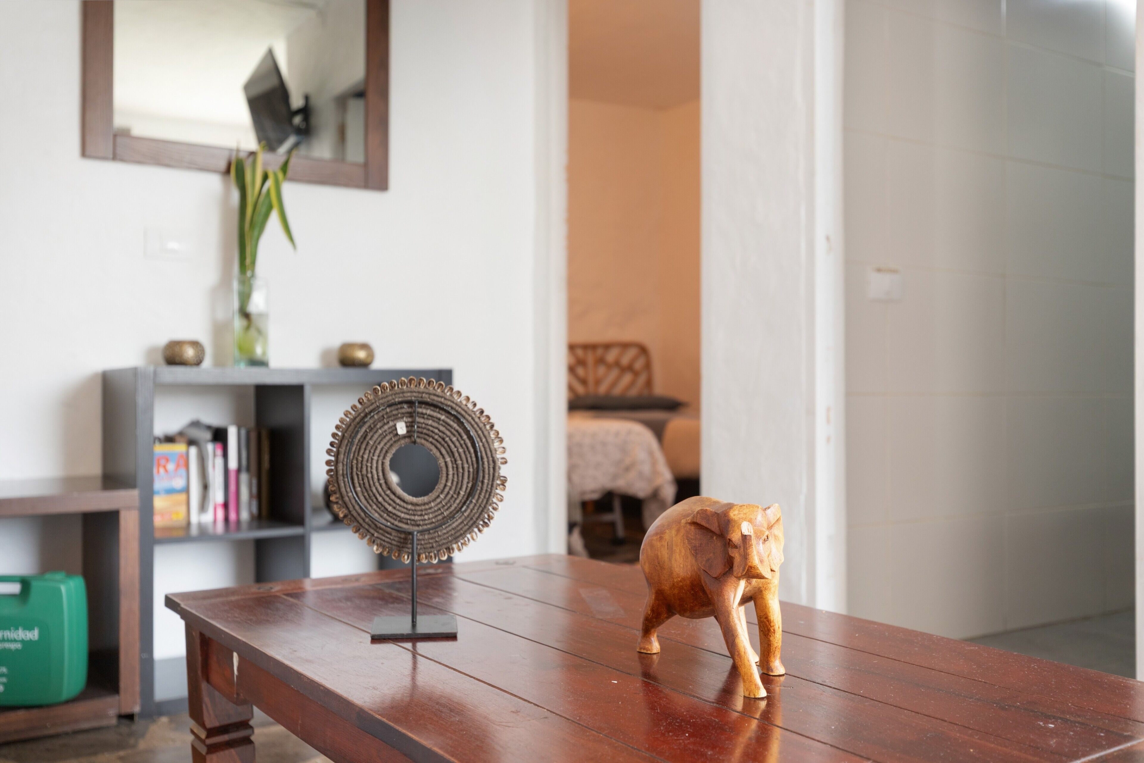 Una mesa de madera con un adorno y una pequeña figurita de elefante.
