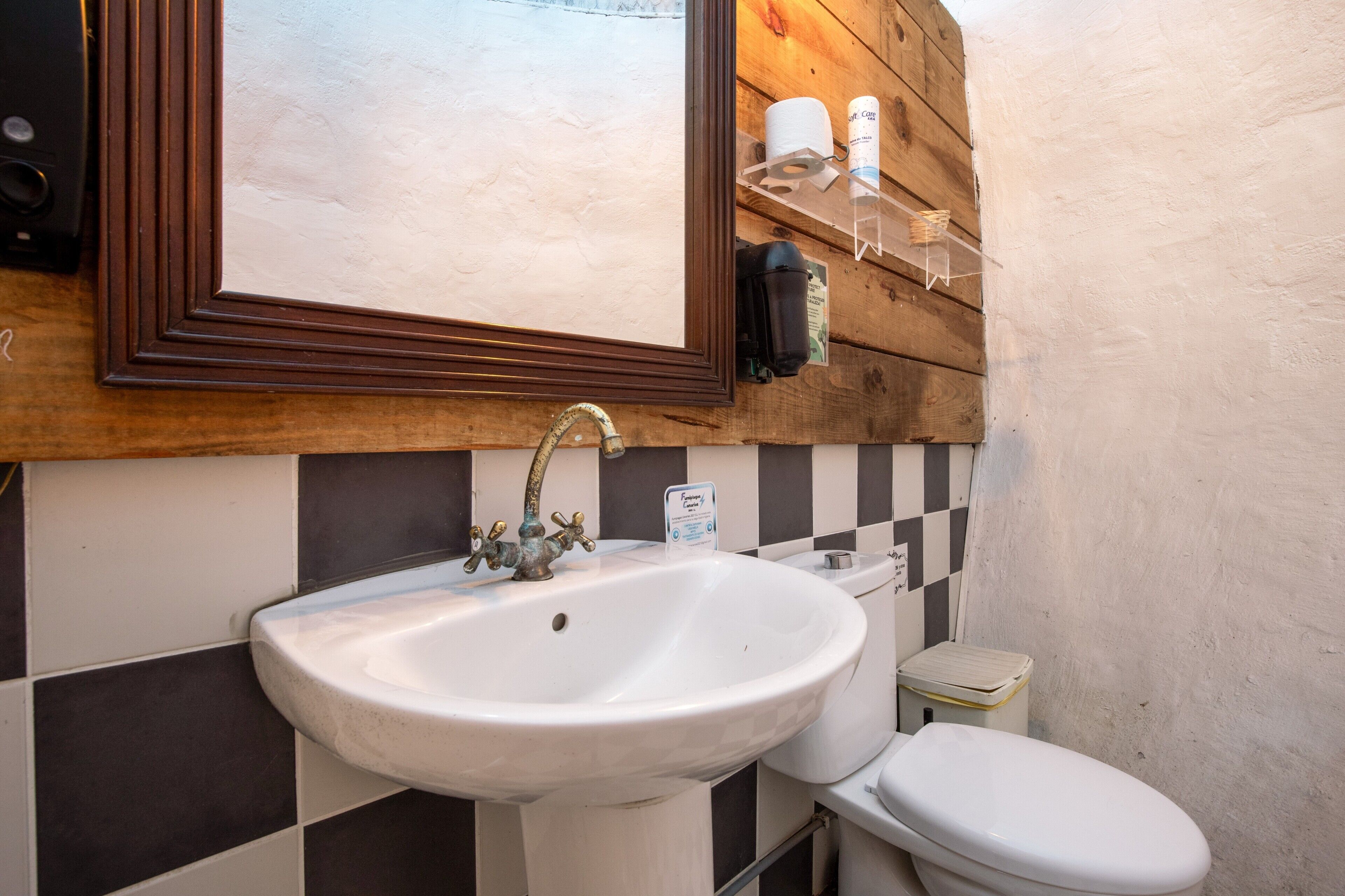 A bathroom with a white sink, a toilet, and a mirror above the sink.