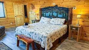 Ein Schlafzimmer einer Holzhütte mit einem Bett, einer Bank, einem Nachttisch und einem Wandheizkörper.