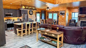 Ein Interieur einer Hütte mit Küche, Essbereich und Sitzgelegenheit.