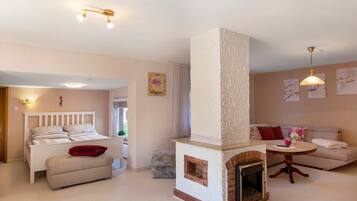Una habitación acogedora con cama, sofá, chimenea y mesa de comedor.