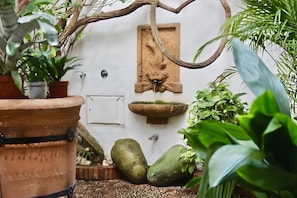 A garden with potted plants, a stone wall, and a water feature. - Apartment 'Siglo Xvii' with Balcony, Wi-Fi and Air Conditioning (El Puerto de Santa María)