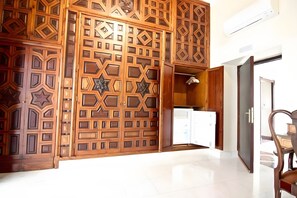 A room with a wooden partition with geometric patterns, a white door, and a chair. - Apartment 'Siglo Xvii' with Balcony, Wi-Fi and Air Conditioning (El Puerto de Santa María)