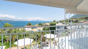 Ein Balkon mit Blick auf das Meer, Berge und umliegende Gebäude.