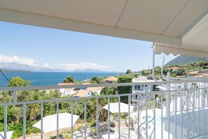 A balcony with a view of the sea, mountains, and surrounding buildings. - Room '1st Floor' with Sea View, Shared Pool and Wi-Fi (Nikiana)