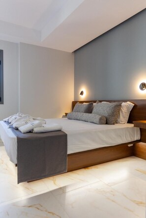 A modern bedroom with a bed, bedside tables, and a nightstand. - Marina A1 Apartment with Jacuzzi, Sea View, Wi-Fi and Air Conditioning (Kardamyli)