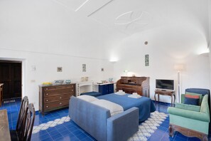 Une chambre avec deux lits, un bureau, une télévision et une chaise.
