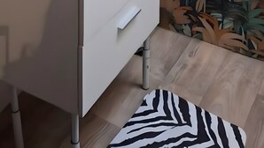 Kylpyhuone, jossa on valkoinen pesuallas, puukehysinen peili, seinään kiinnitetty valaisin ja kuviollinen tapetti.