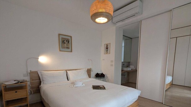 Une chambre à coucher avec un lit, une table de chevet, une lampe et une armoire.