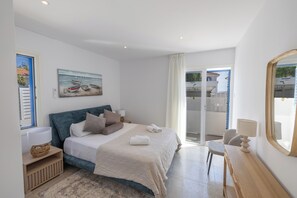 Une chambre à coucher avec un lit, une table de chevet, une chaise, une fenêtre et un tableau.