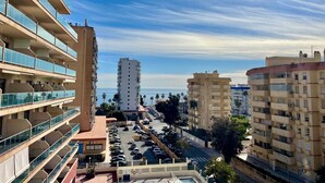 Un immeuble résidentiel à plusieurs étages, doté de balcons, d’un parking et offrant une vue dégagée sur la mer.