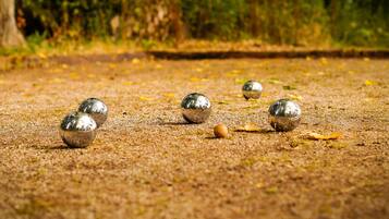Een close-up van glanzende metalen ballen op een geribbelde ondergrond, mogelijk een speel- of activiteitenruimte.