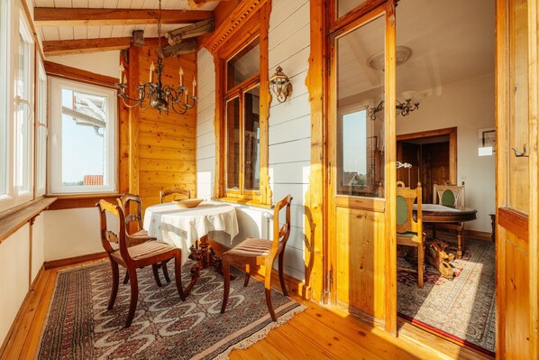 Un intérieur en bois comprenant une table à manger, des chaises et un lustre.