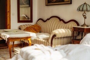 Une chambre avec un lit, une table de chevet, une lampe, un miroir et un tableau encadré au mur.