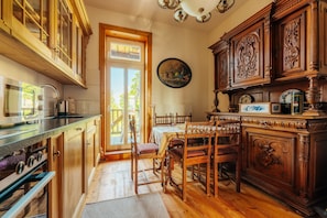 Une cuisine avec des meubles en bois, une table à manger avec des chaises et un lustre.