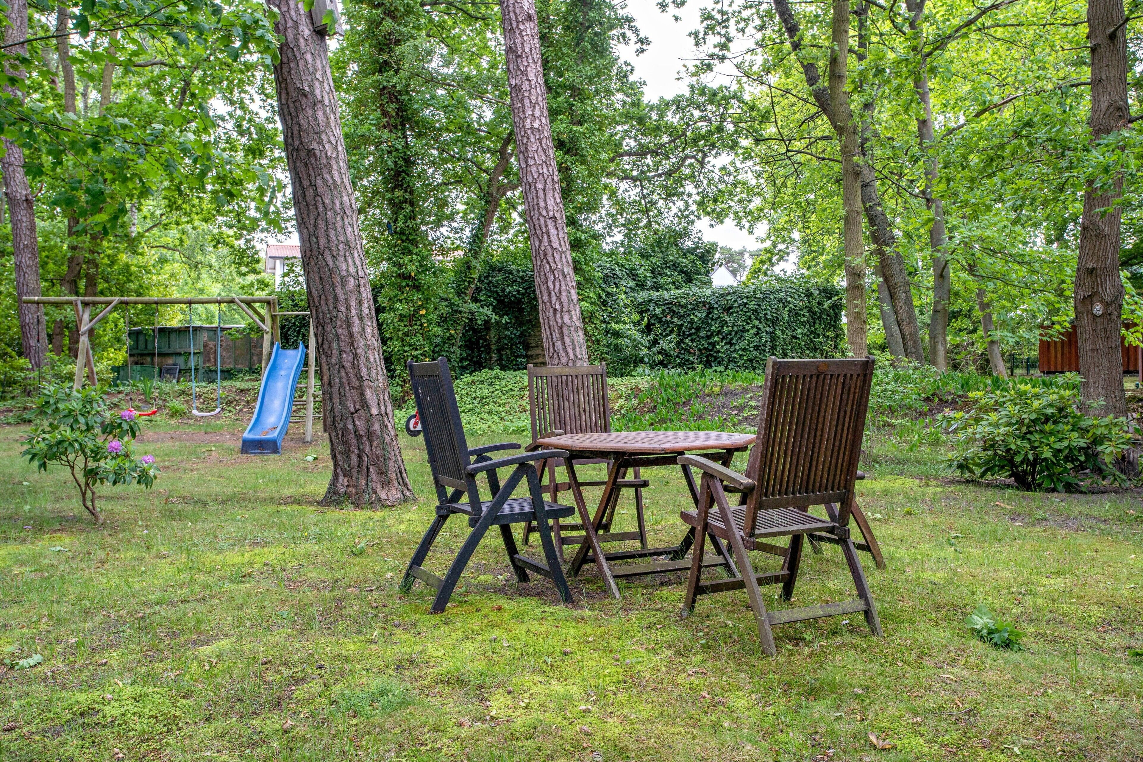 Ein Park mit einem Spielplatz, einem Tisch und Stühlen.