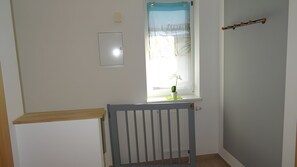 A room with a window, a radiator, and a door with a curtain. - Apartment for 2 Guests (55 m²) in Baabe (Baabe)