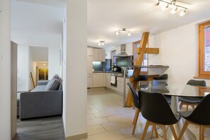 Une cuisine moderne avec un coin repas, un canapé et un escalier.