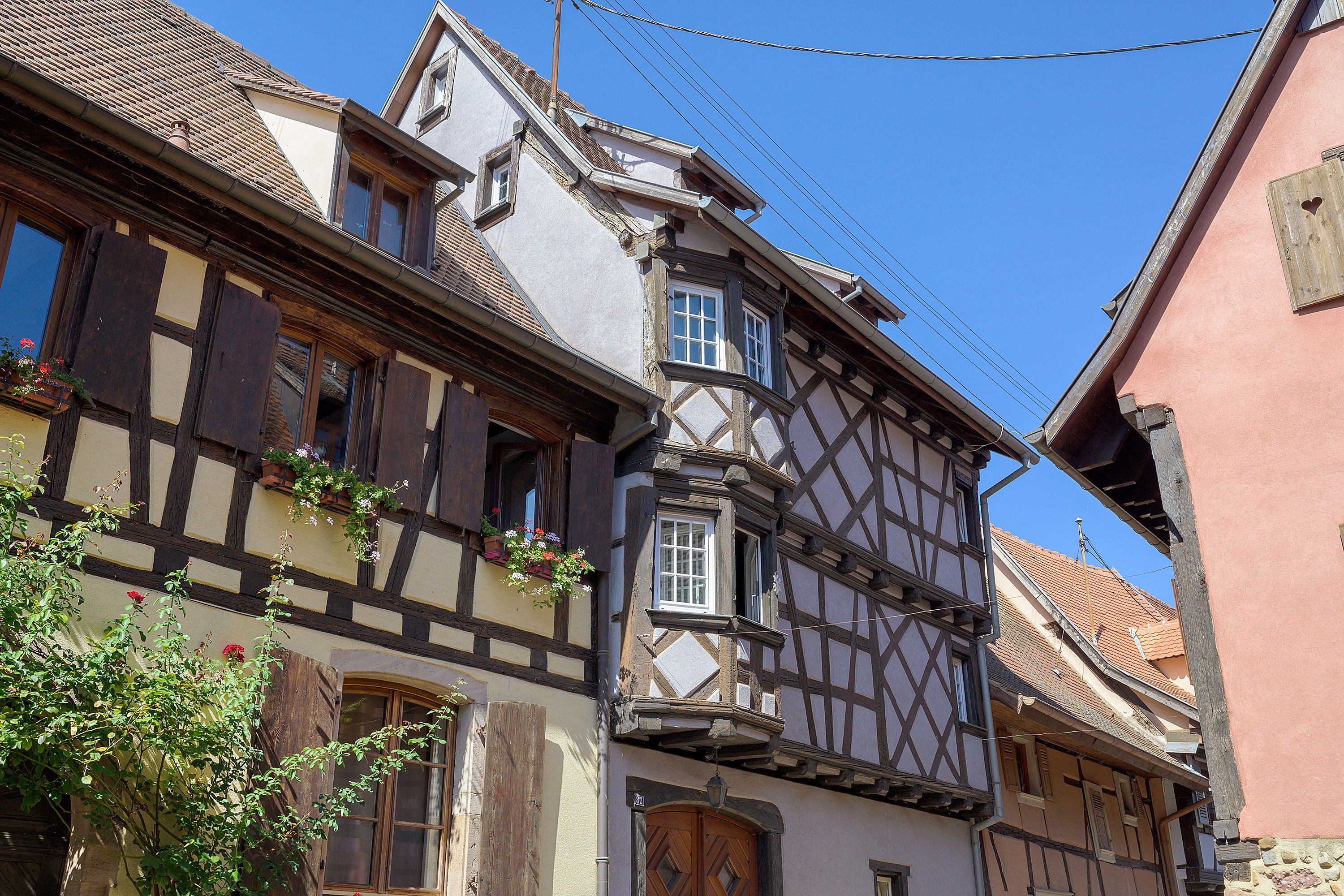 A traditional half-timbered building with a steeply pitched roof, dormer windows, and a wooden door.