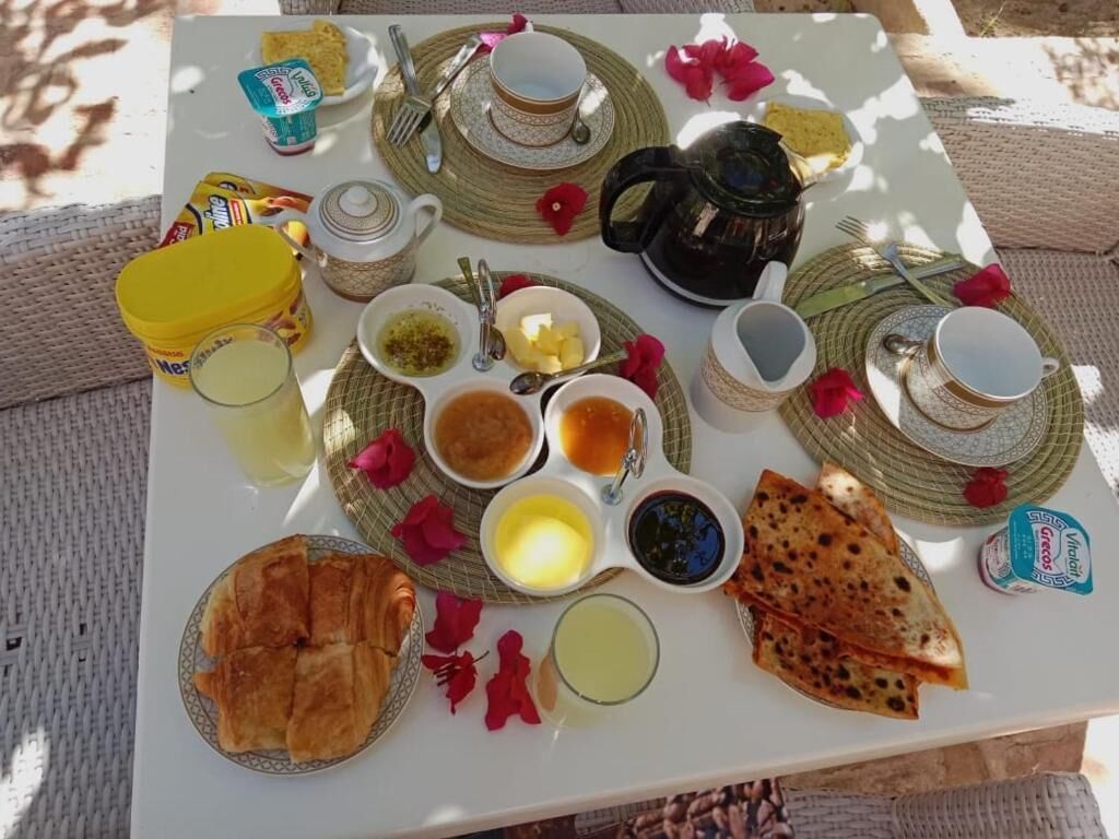 A breakfast tray with various foods and drinks, including bread, pastries, and tea.